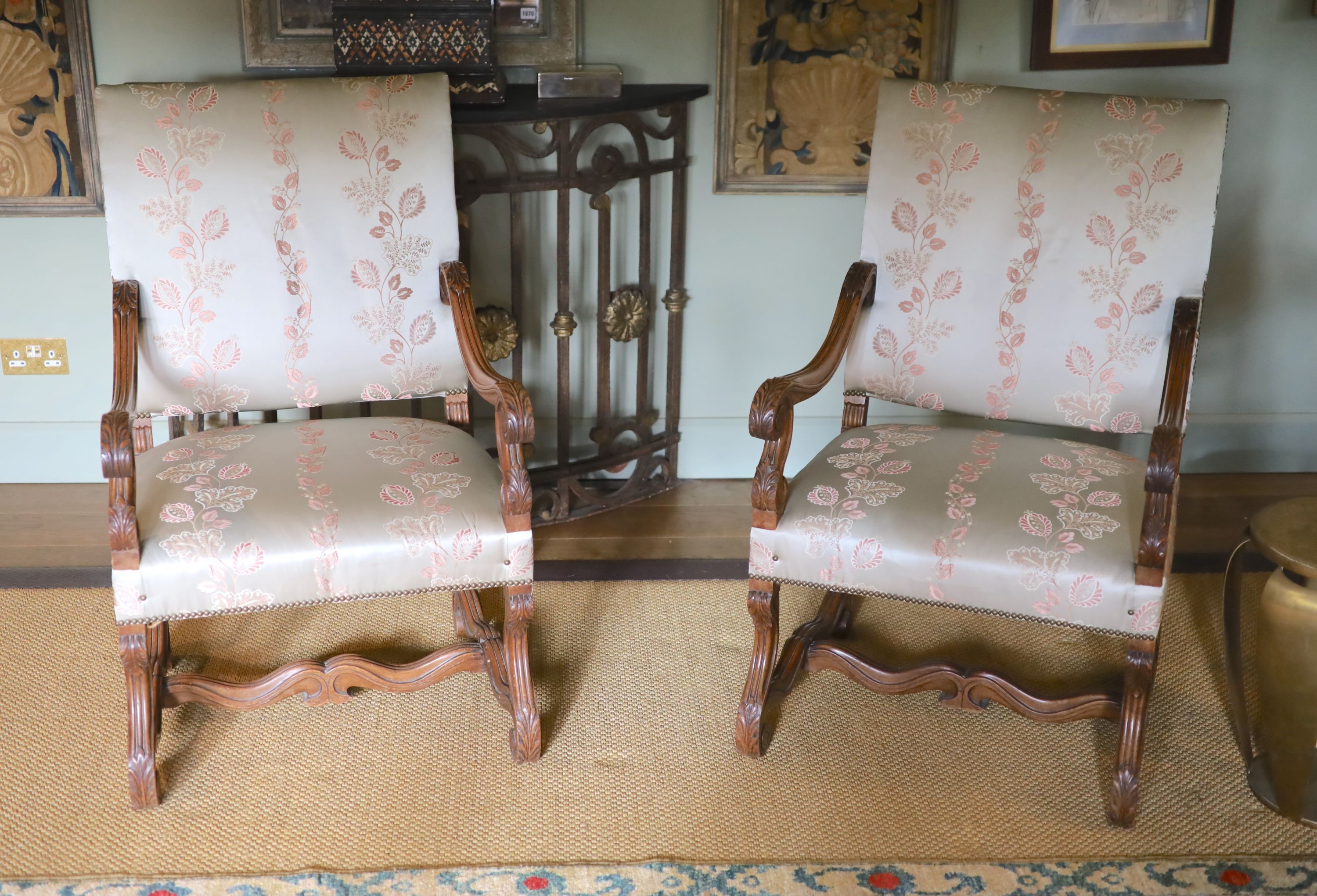 A pair of French carved walnut fauteuils, with machine embroidered eau de nil silk upholstery, width 66cm height 106cm